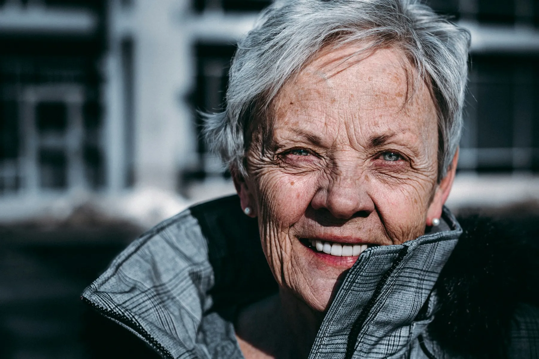 A silver-haired woman smiling in the sunshine